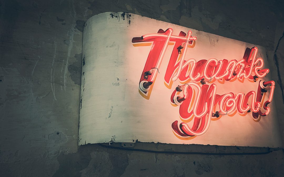 old vintage weathered neon sign reading thank you in coral